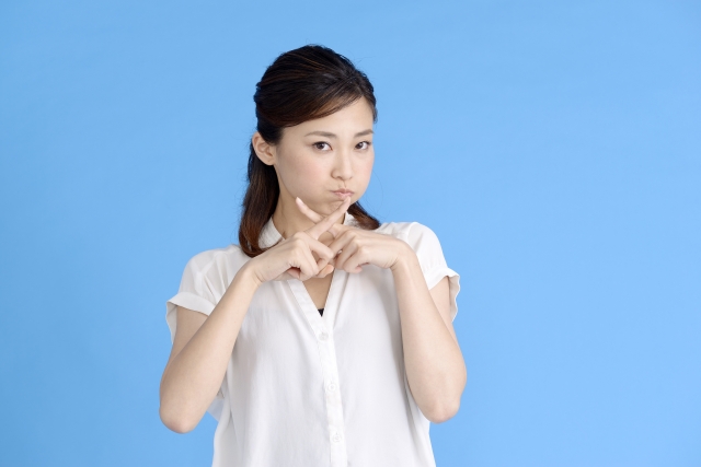 人差し指で×を表す女性