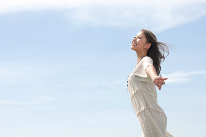 南風に吹かれて爽快な笑顔の女性