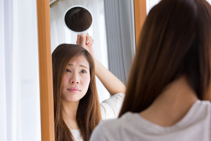 合わせ鏡で後頭部をチェックする女性