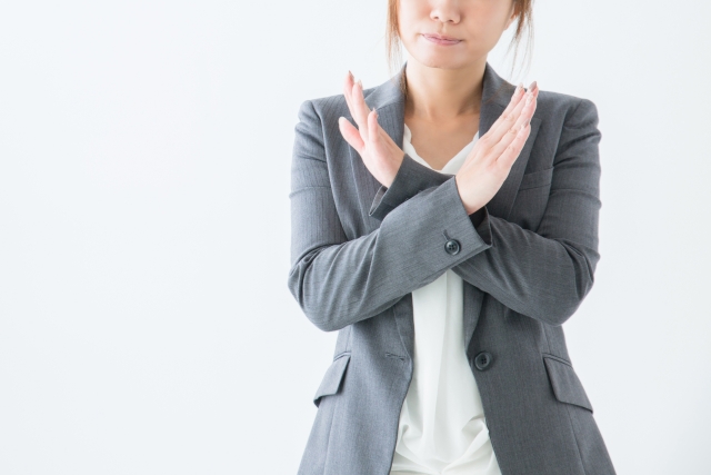 両腕で×をする女性