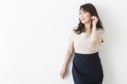 髪をかき上げる笑顔のミドル女性